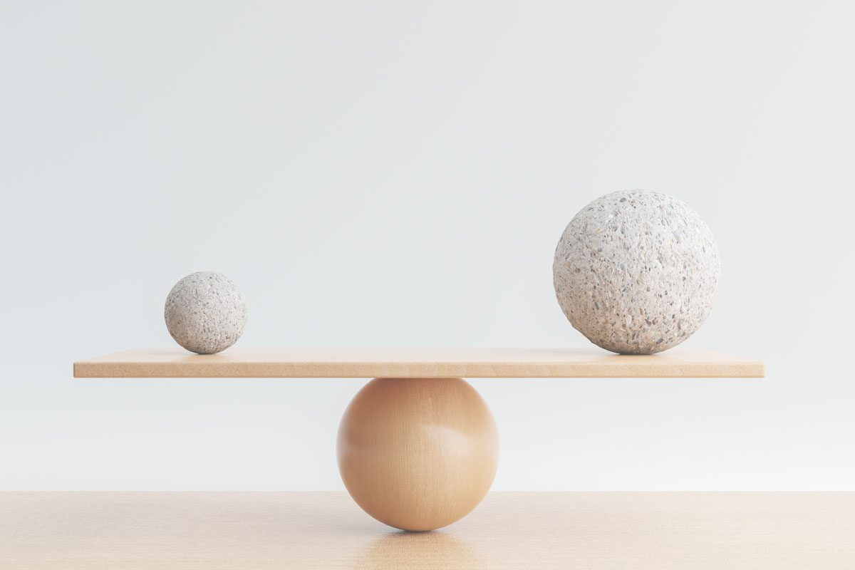 Image of two different sized wooden balls being balanced on a scale for What are the implications of cutting inheritance tax blog